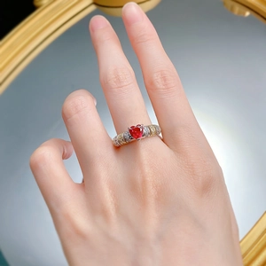 Détail d'une bague rubis cœur rouge sang de pigeon avec anneau serti de diamants sur main
