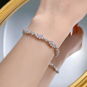 Nahaufnahme eines glitzernden Blumen-Diamantarmbands am Handgelenk mit Spiegelung