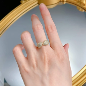 Dettaglio di anello bohémien dorato con doppie gocce d'acqua e micro-pavé di zirconi