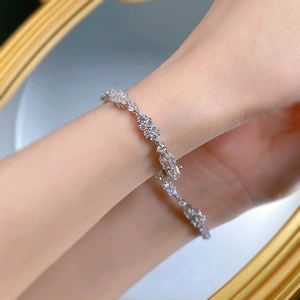 Makroaufnahme eines Armbands aus 925er Silber mit Zirkonia-Blüten am Handgelenk