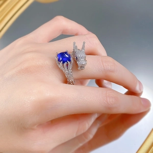 Dettaglio dell'anello a drago in argento S925 con zaffiro blu su dito femminile