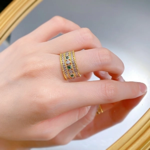 Macro shot of S925 silver gold-plated ring with square green stones and pave crystals