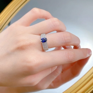 Vue rapprochée d'une bague saphir bleu ovale avec sertissage pavé à trois rangs