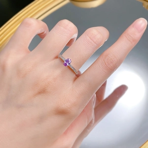 Close-up of S925 silver ring with oval purple gemstone and side diamond accents on finger