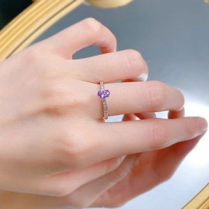 Detail showing an oval purple carbon diamond ring set in S925 silver on a woman's finger