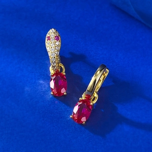 Elegant gold snake earrings featuring red oval gemstones and sparkling cubic zirconia stones