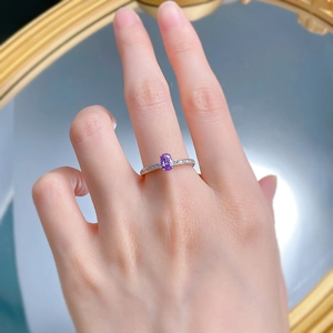 Close-up of a hand wearing an oval purple carbon diamond ring with S925 silver band