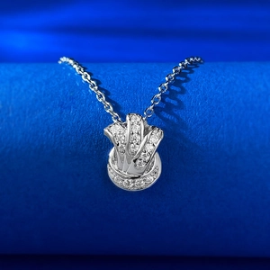 Vue macro d'un collier pendentif nœud en argent serti de zircons sur support bleu