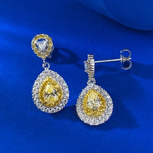 Macro shot of S925 silver pear-cut yellow zircon drop earrings with halo setting detail