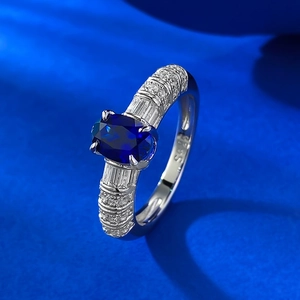 925 silver ring featuring oval royal blue sapphire stone on blue silk background