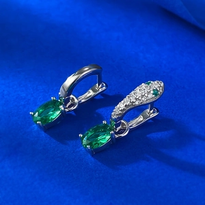 Detail of silver snake-head earrings with green oval stone and sparkling micro-inlay
