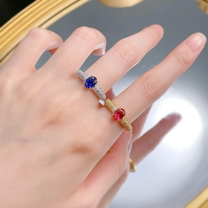 Close-up of royal blue sapphire ring with diamonds on model hand with mirror reflection