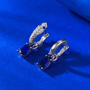 Detailed macro view of S925 silver hoop earrings with oval blue sapphires and pavé zircons