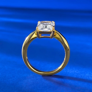 Detailansicht eines Smaragdschliff Edelsteins in poliertem Goldring auf blauem Samt