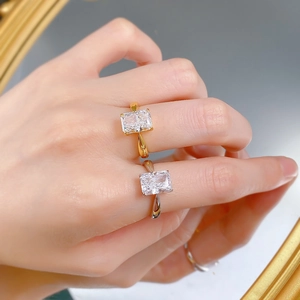 Dettaglio di anelli in oro e argento con pietre rettangolari taglio radiant sulla mano