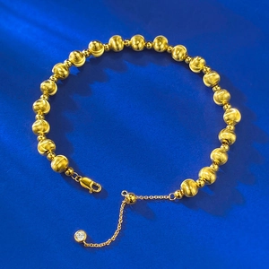 Detailed macro view of S925 sterling silver golden beaded bracelet with lobster clasp