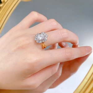 Close-up of a luxury 925 silver oval-cut halo ring with a twisted gold-plated band on hand