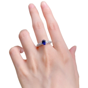 925 silver ring featuring oval royal blue stone and baguette side diamonds on finger