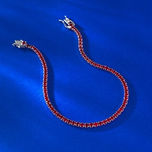 Close-up of S925 silver tennis bracelet with red round-cut zircons and double safety clasp