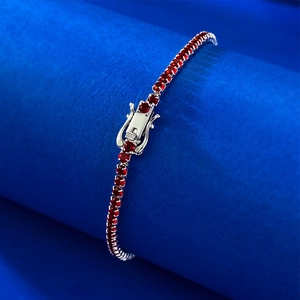Sparkling S925 silver tennis bracelet featuring vibrant ruby red zircons on blue stand
