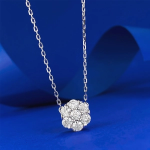 Macro shot of S925 silver flower pendant with brilliant moissanite clusters on blue silk