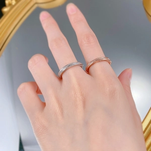 Detail of stacked s925 silver and rose gold diamond pavé rings worn on a hand
