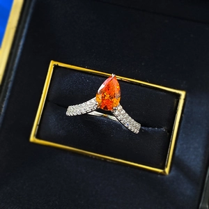 Bague en argent 925 avec pierre orange taille poire et pavé de diamants dans un écrin