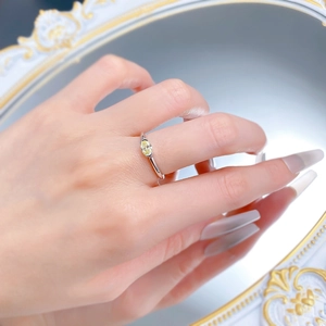 Close-up of S925 silver ring with oval yellow gemstone on a finger in front of a mirror
