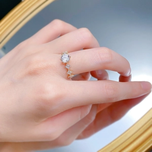 Détail d'une bague en argent S925 avec diamant d'un carat et trèfles sur anneau doré