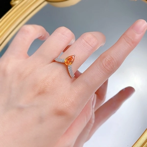 Détail d'une bague en argent 925 avec pierre orange en poire et micro-pavage de diamants