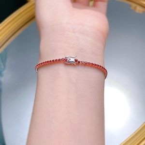 Detail of red zircon tennis bracelet in S925 silver worn on wrist with double safety clasp