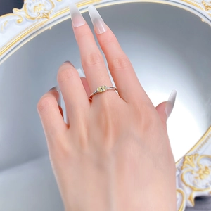 Macro shot of an oval yellow gemstone ring on hand with a vintage mirror background
