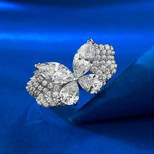 Macro detail of silver butterfly ring with marquise and pear cut crystals on blue silk