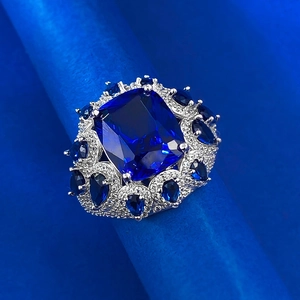 Macro shot of cushion cut blue sapphire ring with cluster of zircon on silver band