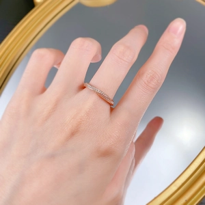 Macro shot of rose gold rope band ring with micro pavé diamonds reflected on mirror