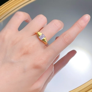 Detail view of a gold S925 silver ring featuring a rectangular purple zircon on a finger