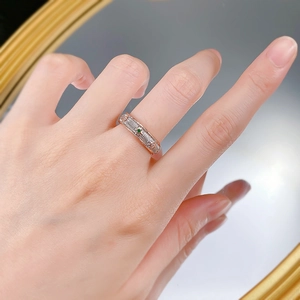Two-tone gold ring with brushed texture, emerald center stone and diamond accents