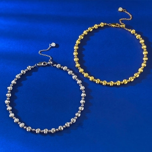 Detail of silver and gold beaded bracelets with laser brushed texture on blue velvet