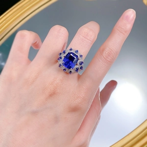 Macro shot of a 925 silver ring featuring a large square blue corundum and halo of crystals