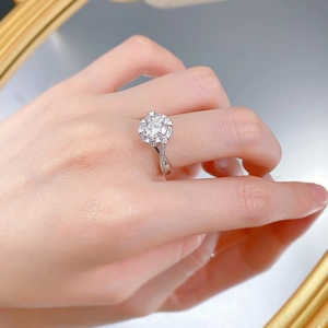Detailed view of moissanite ring with floral petal setting and diamond pavé band
