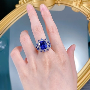Macro view of blue sapphire rectangular stone with pavé setting and silver finish