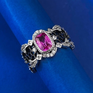 Détail de la bague en pierre rose avec diamants blancs et anneau en argent à motif alvéolé