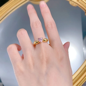 Gros plan d'une bague vintage en or avec pierre précieuse rose en forme de cœur