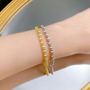 Macro detail of minimalist S925 sterling silver beaded bracelets in gold and silver finish