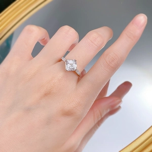 Close-up of S925 silver three-stone ring with emerald cut white diamond on model hand