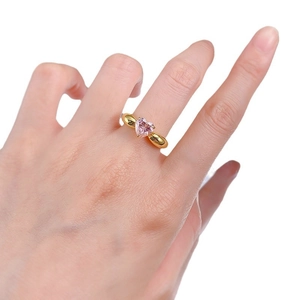 Bague classique en forme de cœur avec pierre rose et anneau doré portée sur la main