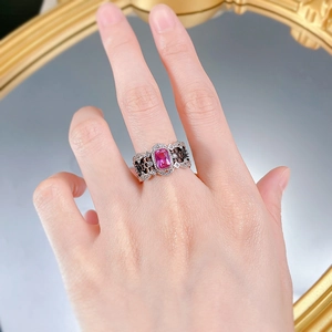 Gros plan d'une bague en argent S925 avec gemme rose rectangulaire portée à la main
