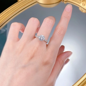 Close-up of a luxury S925 silver halo ring with a round center stone on a model's hand