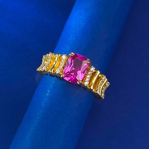 Macro shot of gold-plated S925 ring with pink tourmaline and pavé stones on blue display