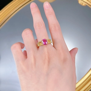 Close-up of a gold-plated silver ring with rectangular pink tourmaline and wavy diamonds